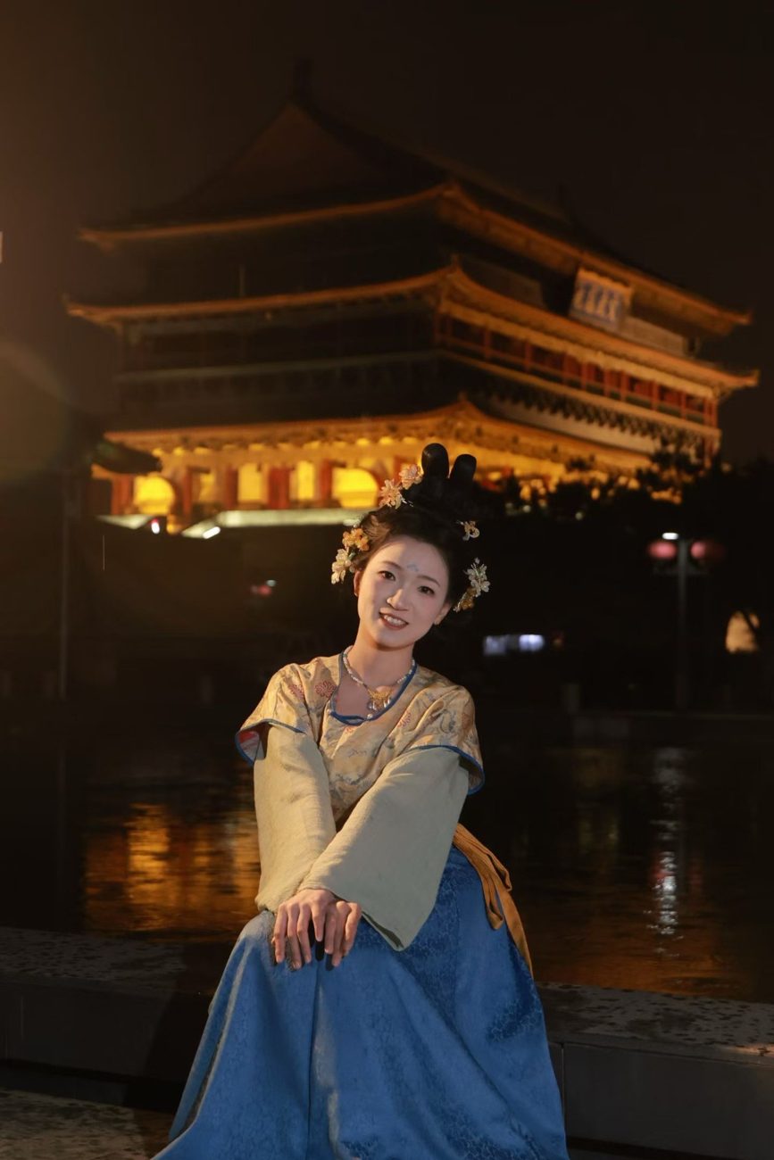 寒诺坐在灯火映照的楼阁前